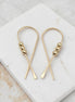 gold ribbon shaped threader earrings with gold beads