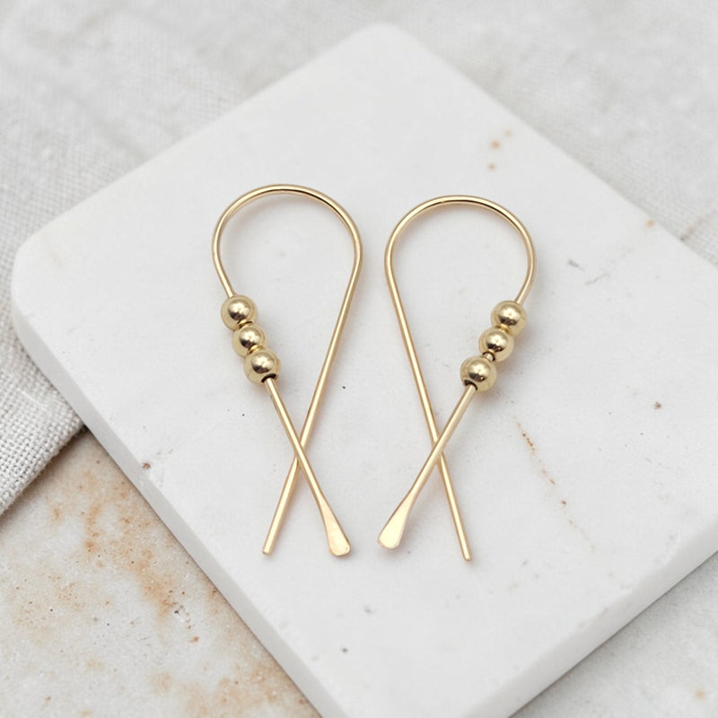 gold ribbon shaped threader earrings with gold beads
