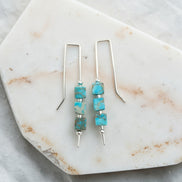 Turquoise beaded earrings on a marble surface
