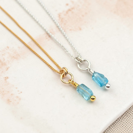 Two necklaces with blue beads on a light background
