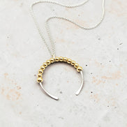 Necklace with gold beaded design on a light background