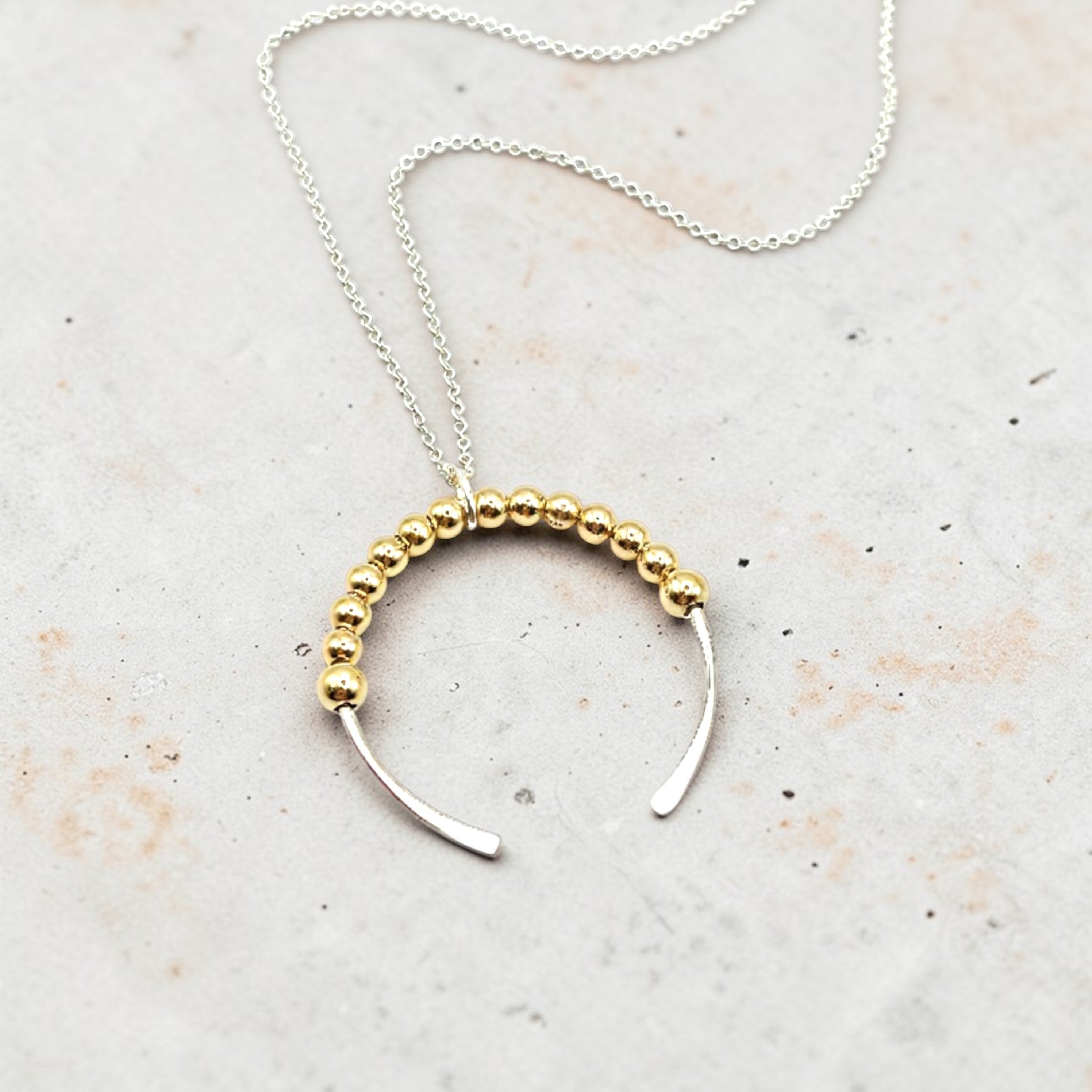 Necklace with gold beaded design on a light background