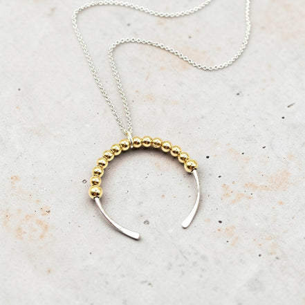 Necklace with gold beaded design on a light background