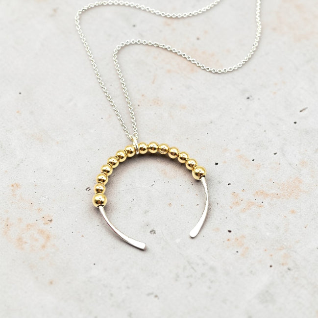 Necklace with gold beaded design on a light background