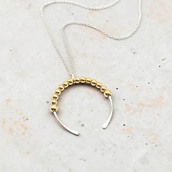 Necklace with gold beaded design on a light background