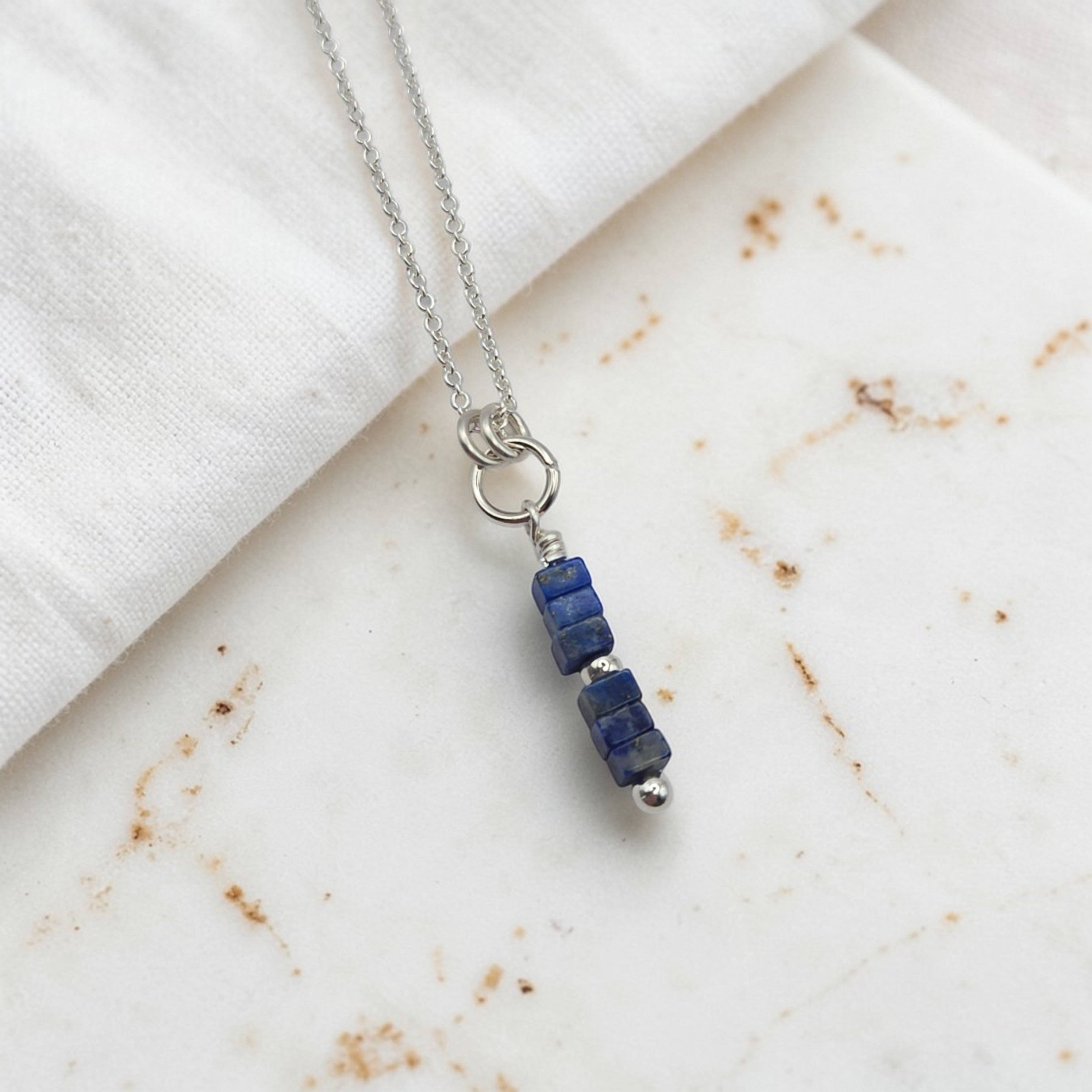 Necklace with blue beads on a marble surface