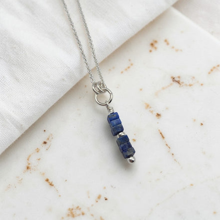 Necklace with blue beads on a marble surface