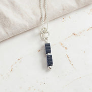 Necklace with black stone pendant on a light background