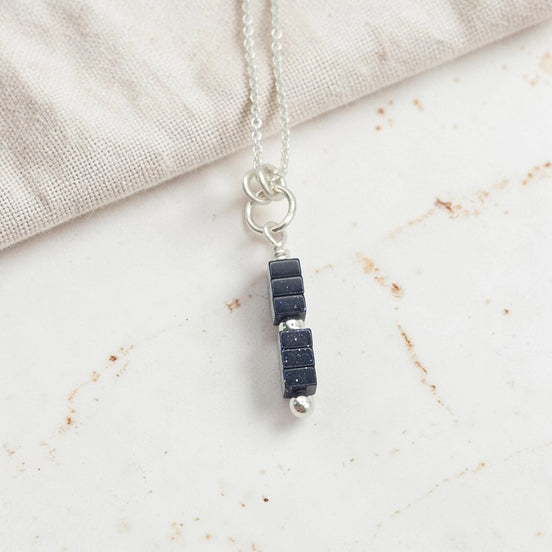 Necklace with black stone pendant on a light background