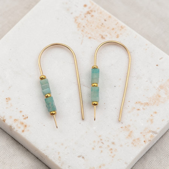 Gold and amazonite beaded earrings on a marble surface