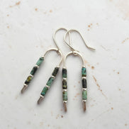 silver wishbone style earrings featuring dark green  african turquoise beads