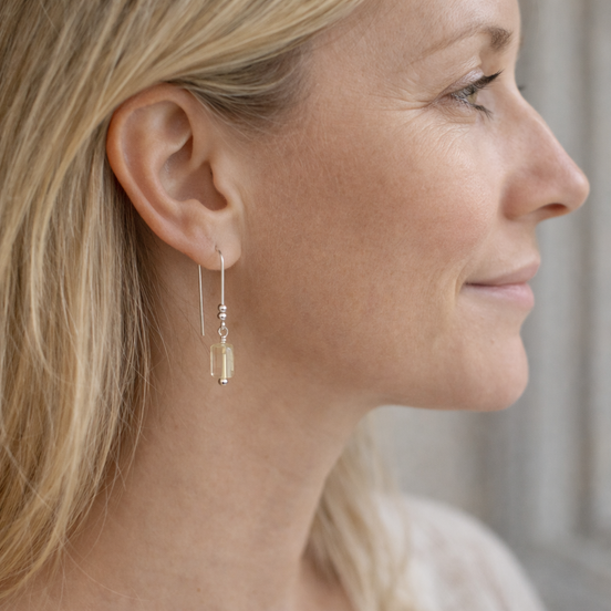 Close-up of a woman wearing a dangling earring with a blurred background