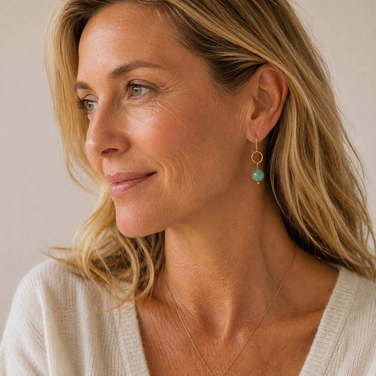 Woman wearing a light-colored top with a neutral background