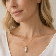 Woman wearing a gold necklace with a pendant