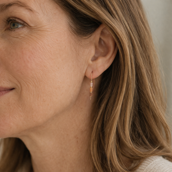 Close-up of a woman wearing an earring with a neutral background