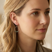 Close-up of a woman wearing hoop earrings with beads.