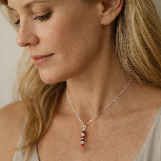 Woman wearing a necklace with red and blue beads, close-up of her neck and face.