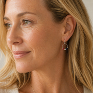 Close-up of a woman wearing red white and blue hoop earrings with a neutral background