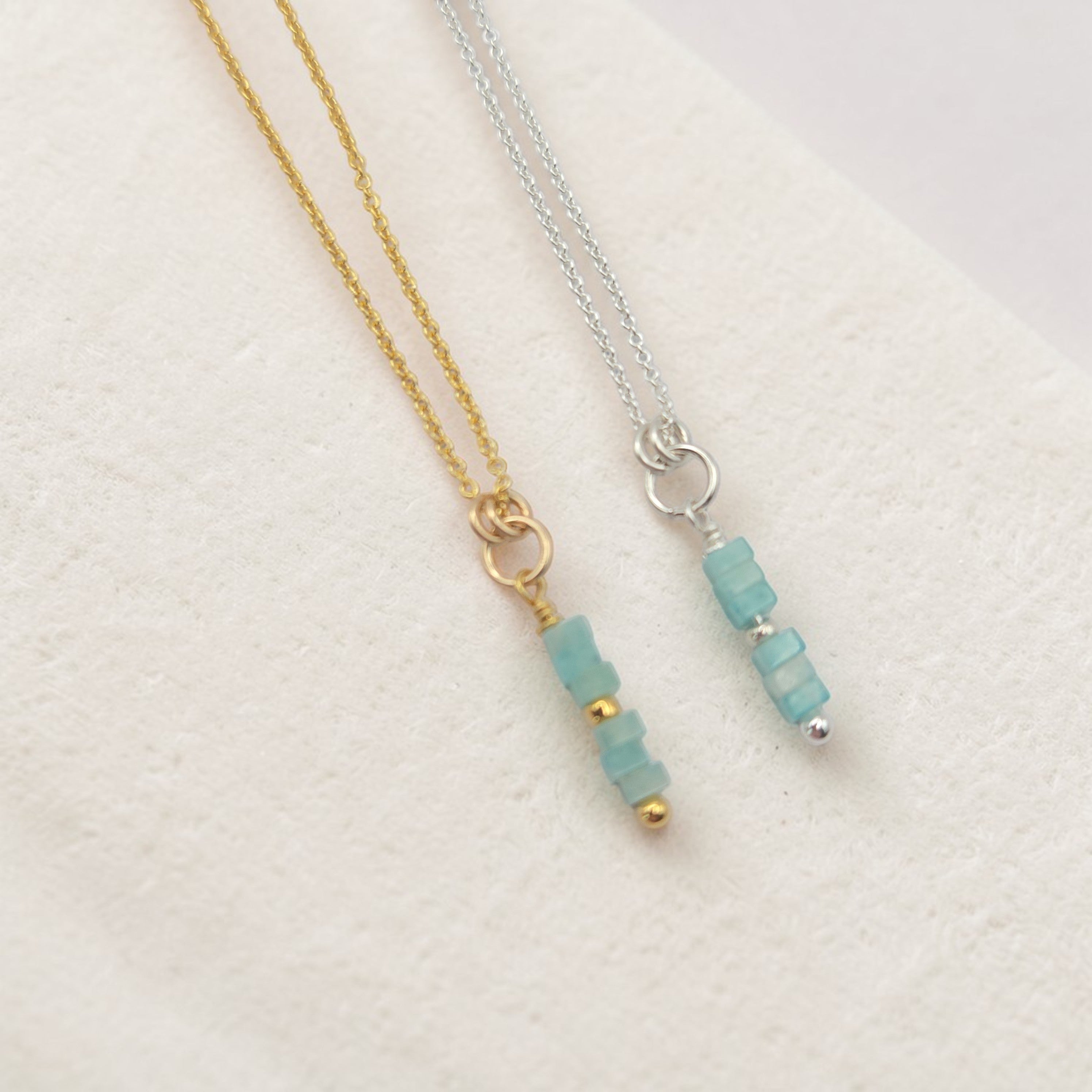 Two necklaces with amazonite bead pendants on a light background