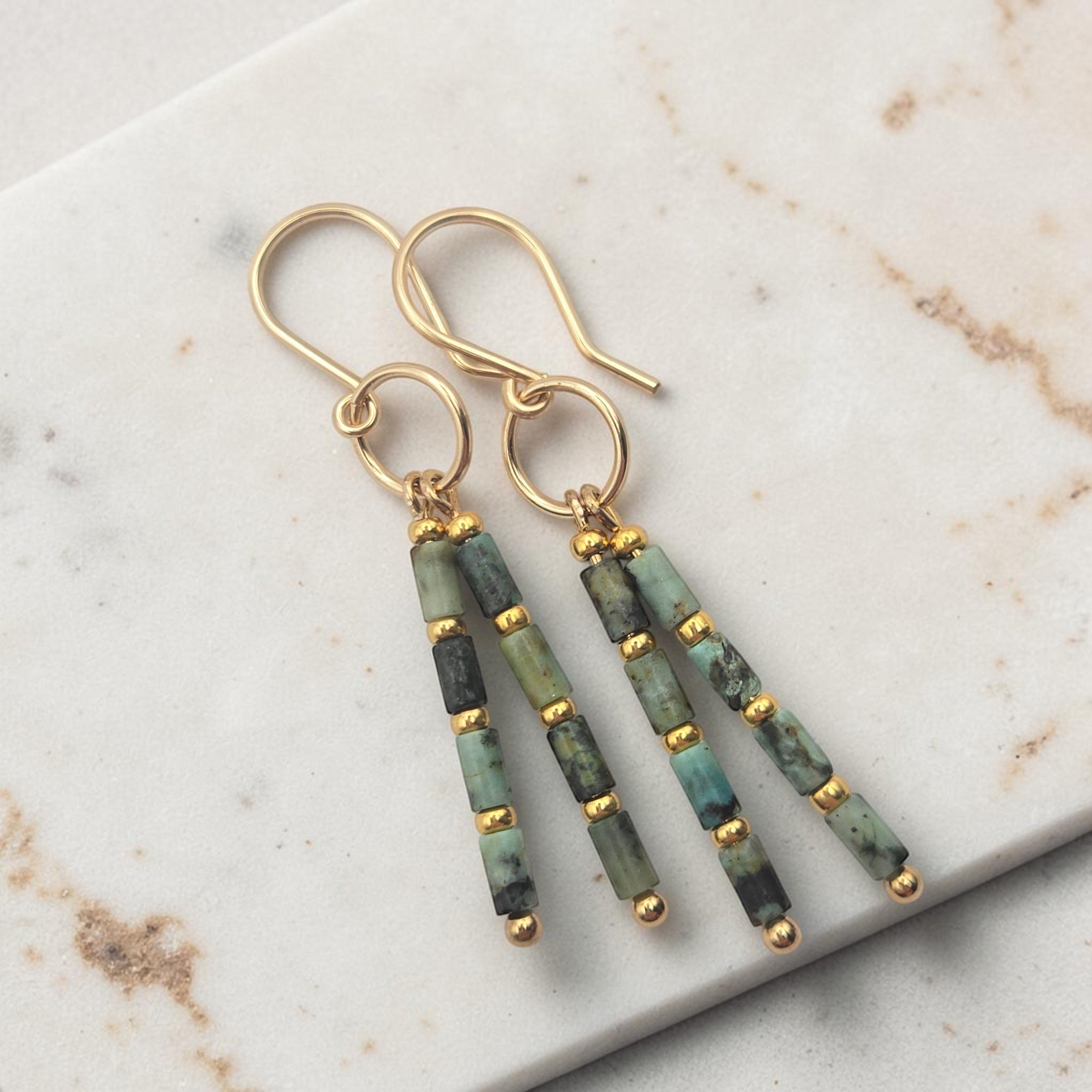 Bijou by SAM Mother Earth earrings featuring African Turquoise tube beads and 14k gold fill hoops on marble surface.