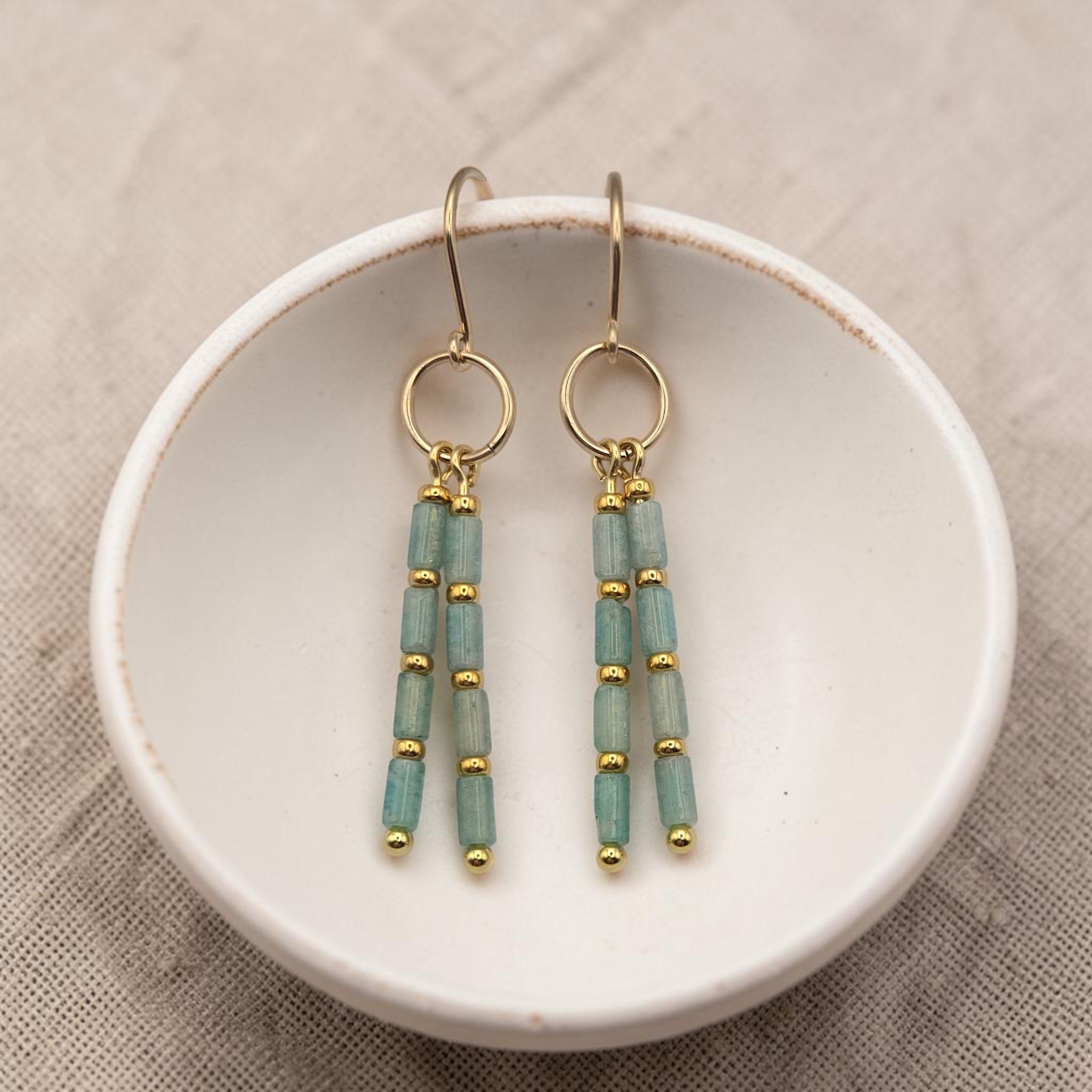 Bijou by SAM River Stone dangle earrings featuring Amazonite tube beads and 14k gold fill hoops on a white ceramic dish.