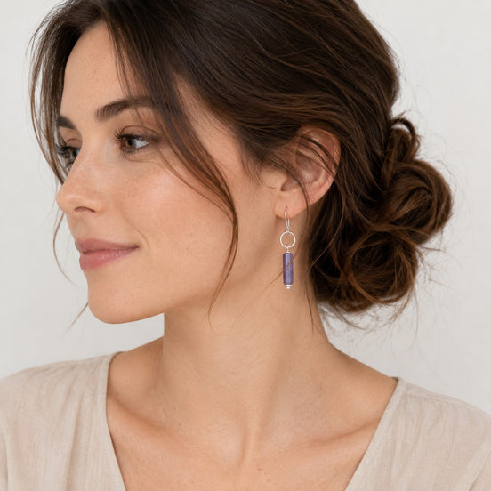 Bijou by SAM handmade sterling silver earrings featuring a dangling purple amethyst cylinder stone on a small hoop.