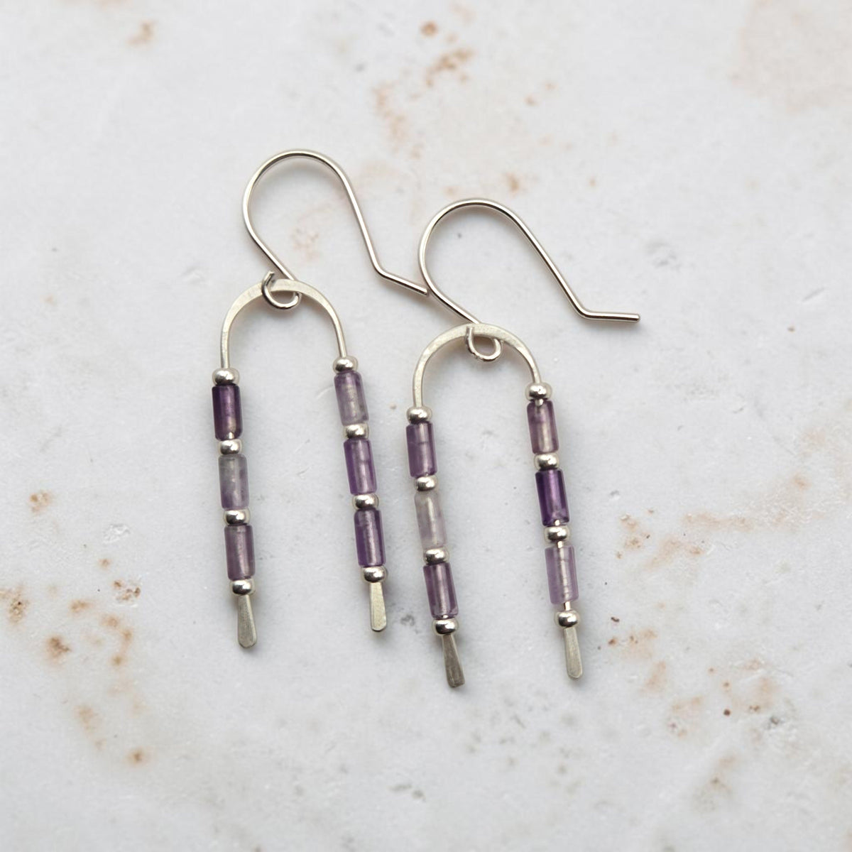 Bijou by SAM handcrafted wishbone earrings featuring purple amethyst tube stones on sterling silver wire arcs.