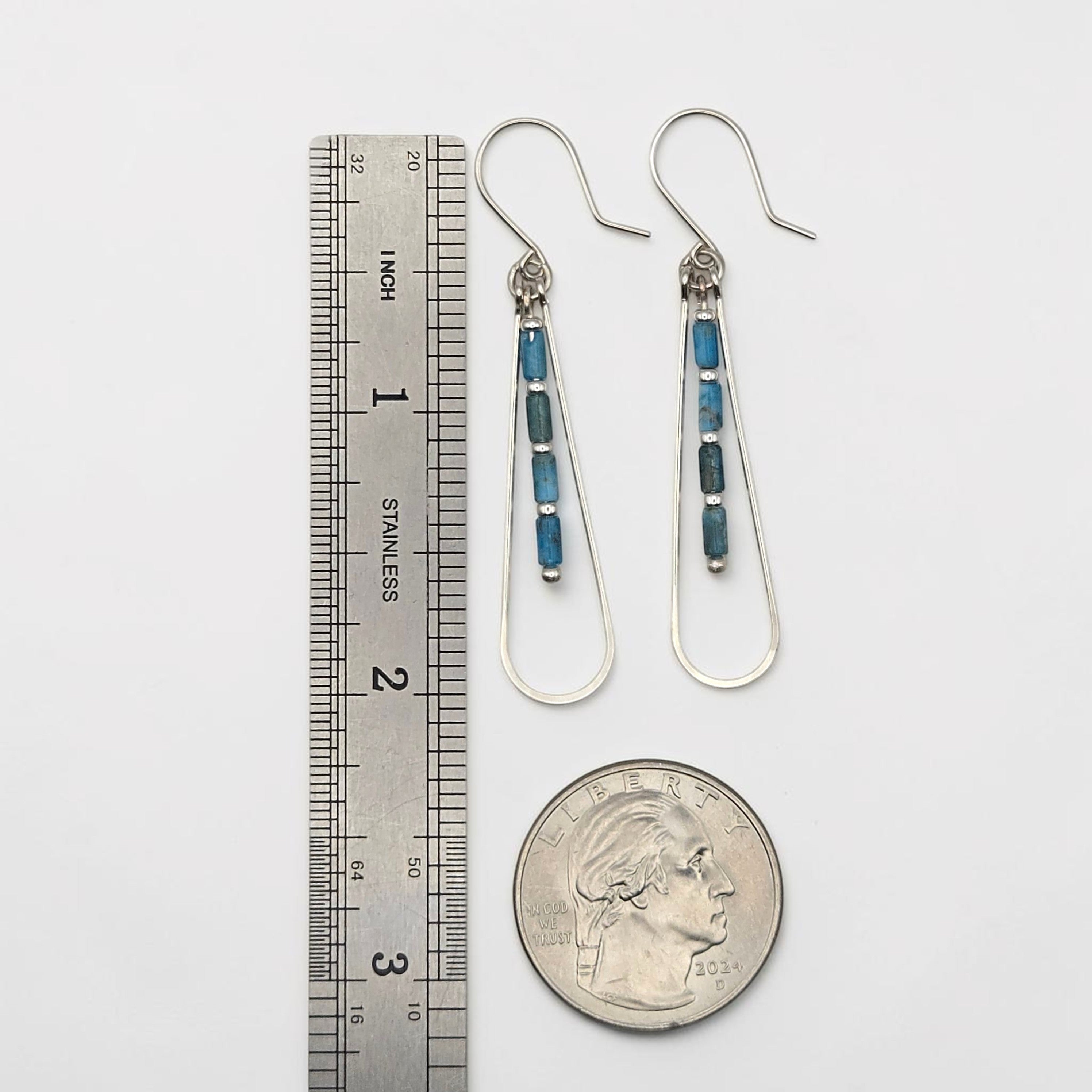Bijou by SAM Still Water teardrop earrings with blue Apatite beads and silver hoops next to a ruler and quarter coin.