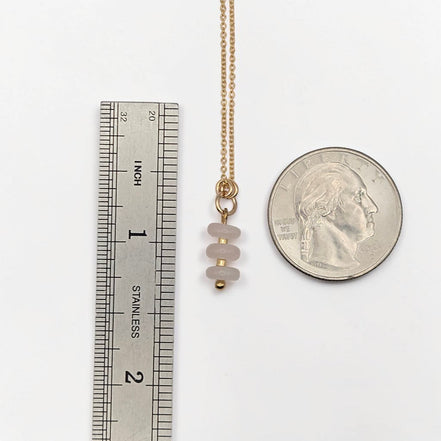 Bijou by SAM Aurora necklace featuring three soft blush rose quartz beads on a delicate gold chain with scale ruler.