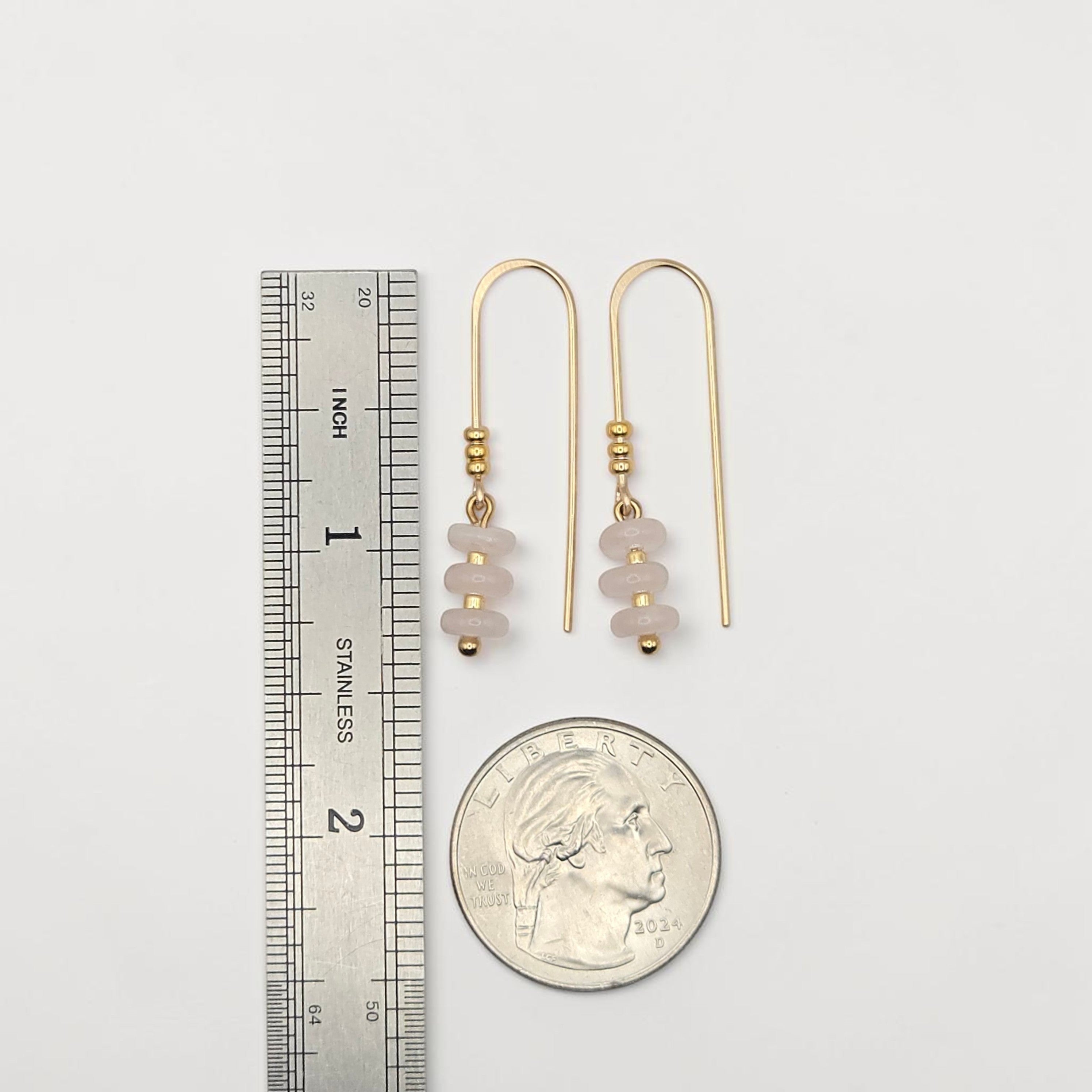 Bijou by SAM Aurora threader earrings featuring blush pink rose quartz beads on 14k gold fill wire next to a coin.