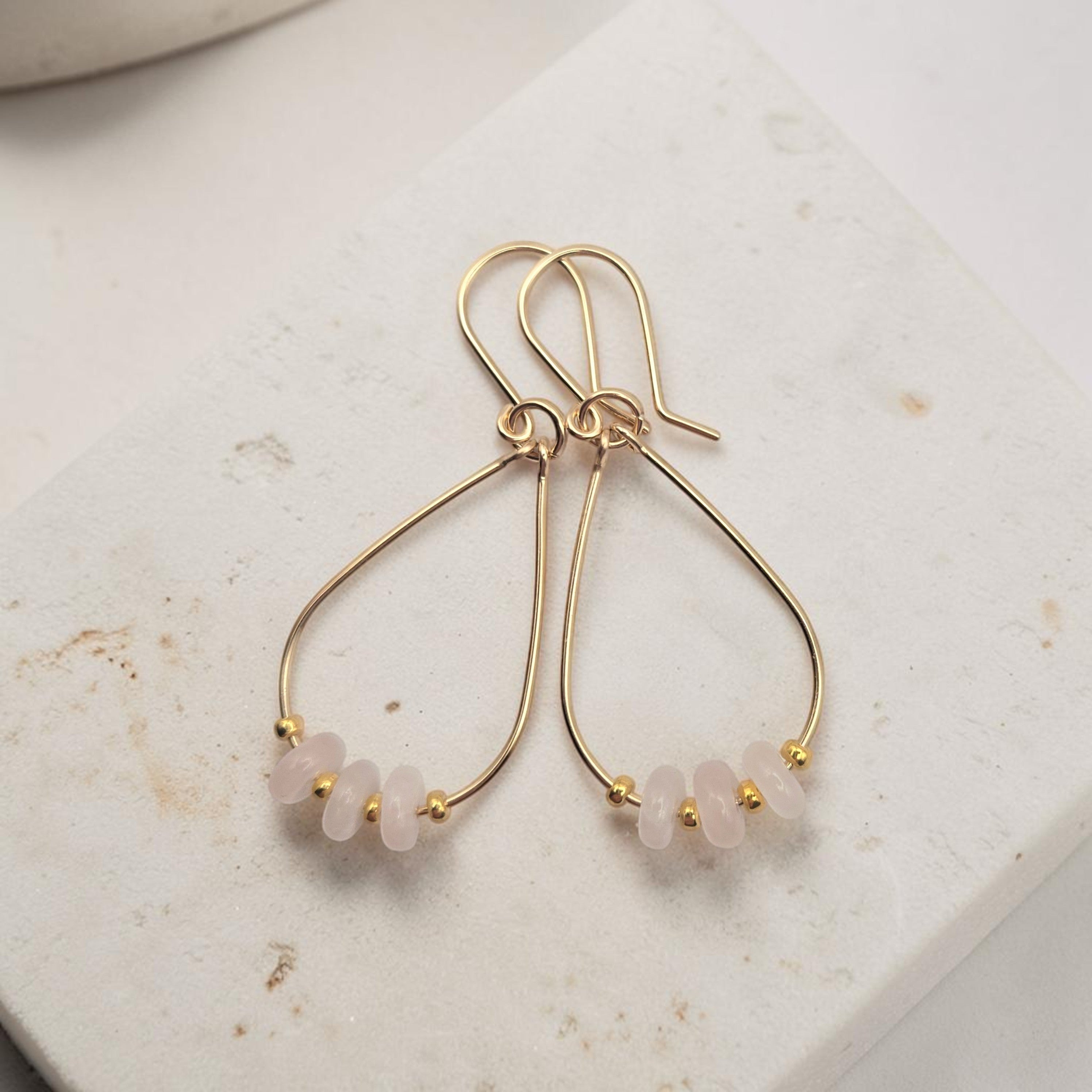Bijou by SAM Aurora teardrop hoop earrings featuring blush rose quartz beads on 14k gold fill wire.