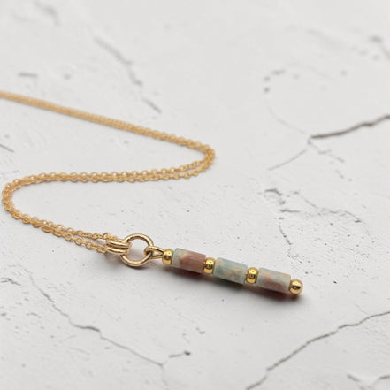 Bijou by SAM Big Sky necklace featuring natural Aqua Terra Jasper tube beads and 14k gold fill chain on white surface