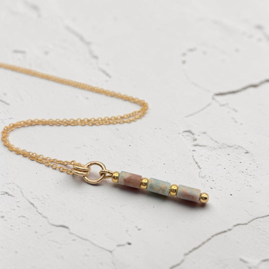 Bijou by SAM Big Sky necklace featuring natural Aqua Terra Jasper tube beads and 14k gold fill chain on white surface