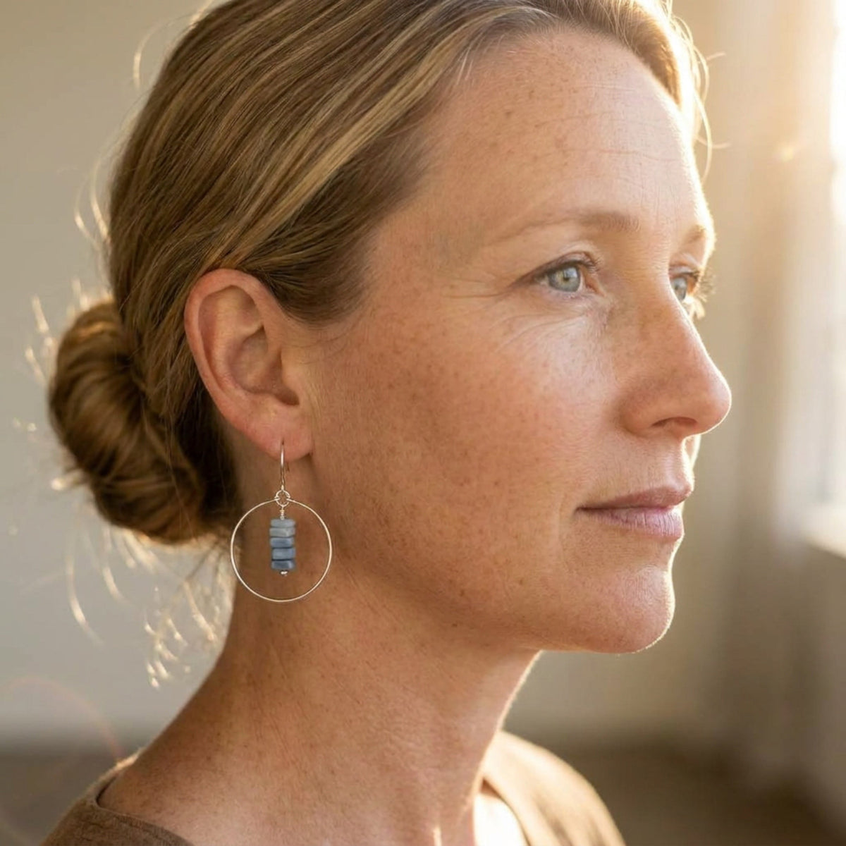 Bijou by SAM handmade hoop earrings featuring a delicate stack of square-cut denim blue opal stones on a woman