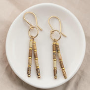 Bijou by SAM Canyon Earrings featuring natural Picture Jasper tube beads and 14k gold fill hoops on a white dish.