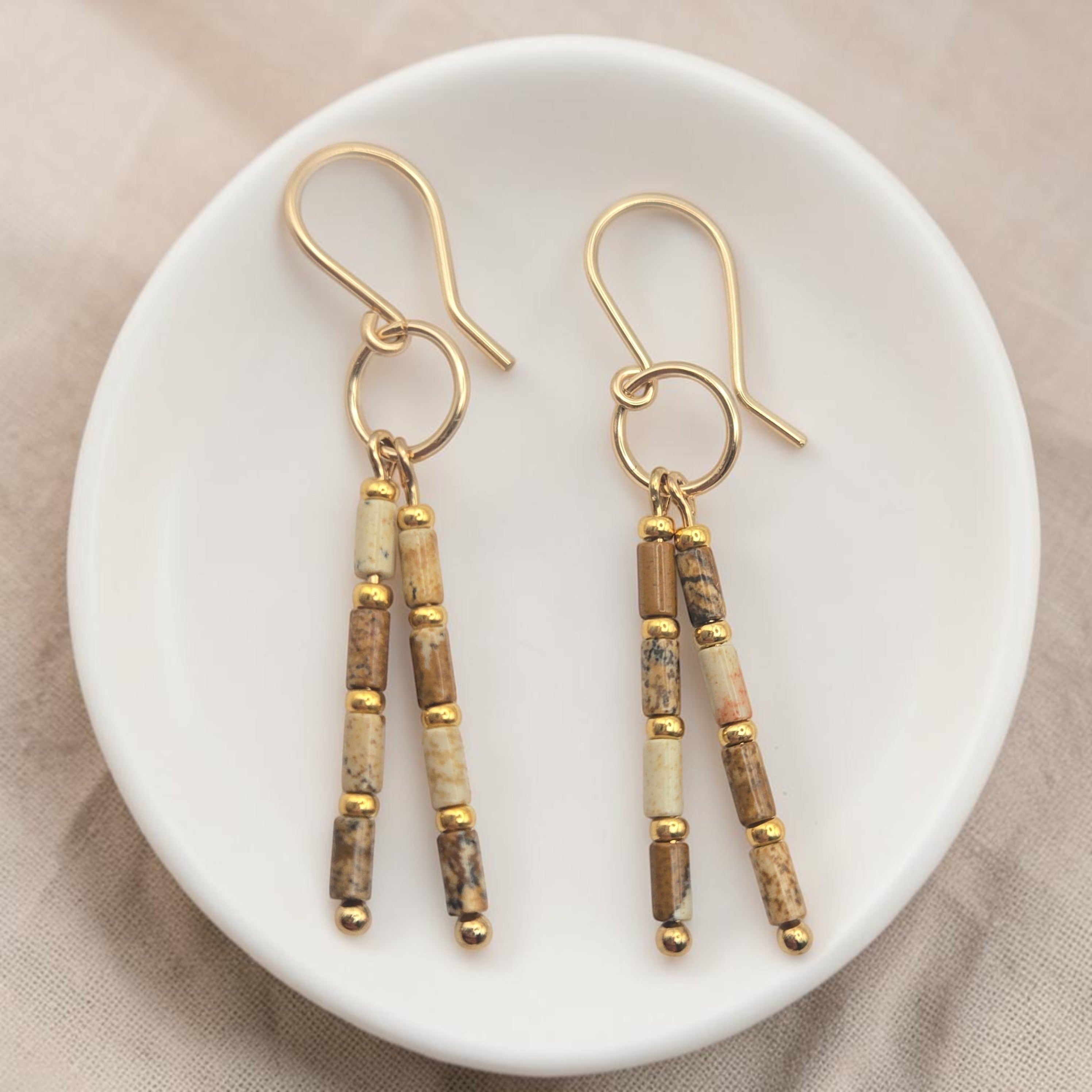 Bijou by SAM Canyon Earrings featuring natural Picture Jasper tube beads and 14k gold fill hoops on a white dish.