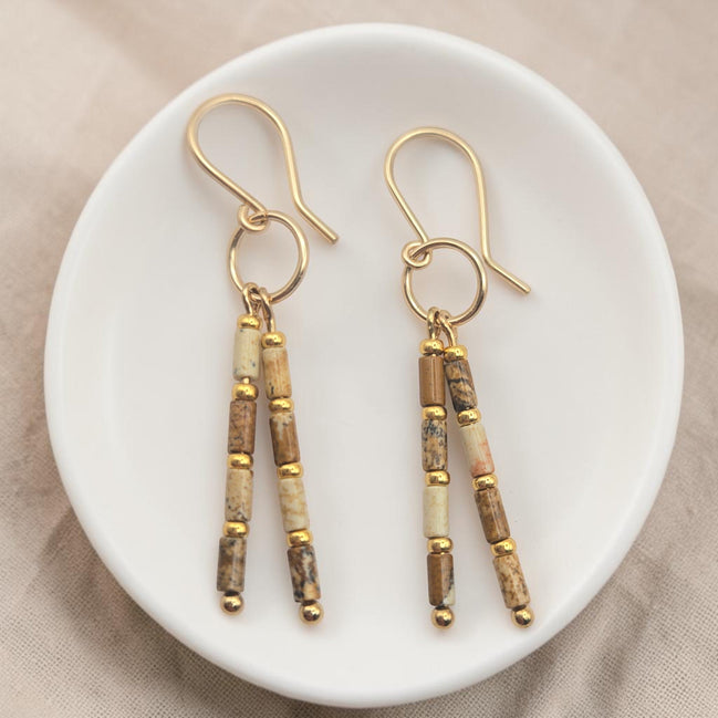 Bijou by SAM Canyon Earrings featuring natural Picture Jasper tube beads and 14k gold fill hoops on a white dish.