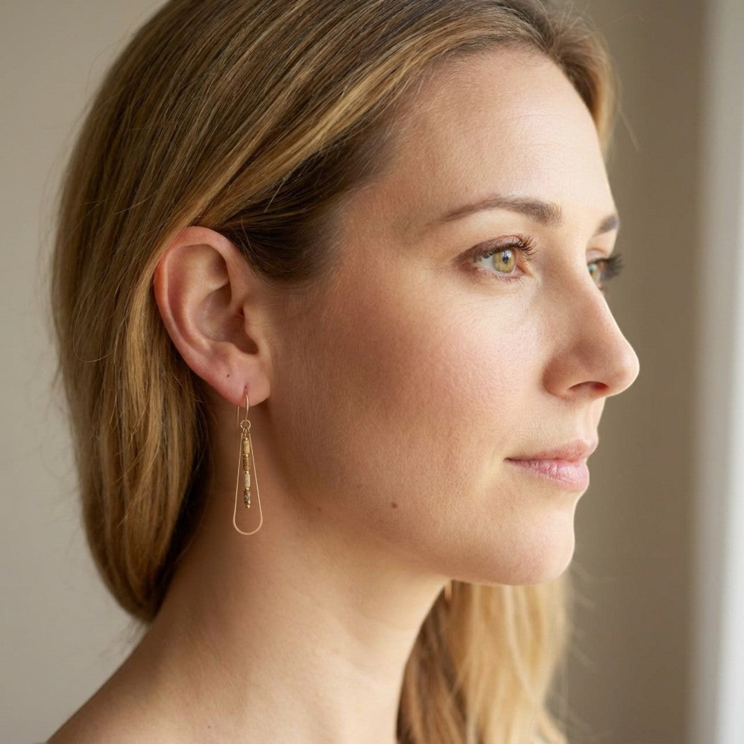 Bijou by SAM Canyon Teardrop Hoops featuring gold fill wire and picture jasper beads worn by a woman in profile.
