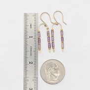 Bijou by SAM handcrafted wishbone earrings featuring purple amethyst tube stones on 14k gold fill wire next to a ruler.