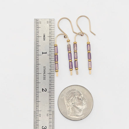 Bijou by SAM handcrafted wishbone earrings featuring purple amethyst tube stones on 14k gold fill wire next to a ruler.