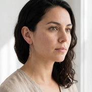 Bijou by SAM gold fringe threader earrings worn by a woman with dark hair, featuring delicate hanging metal bars.