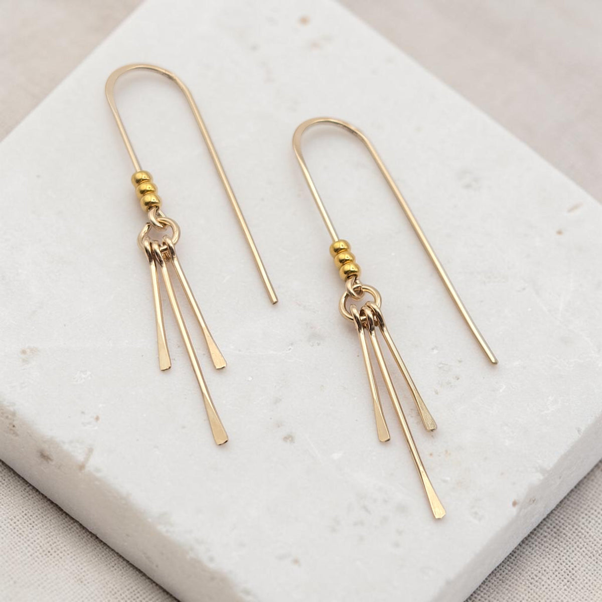 Bijou by SAM minimalist gold threader earrings featuring delicate hoops and three graceful hanging metal fringes.