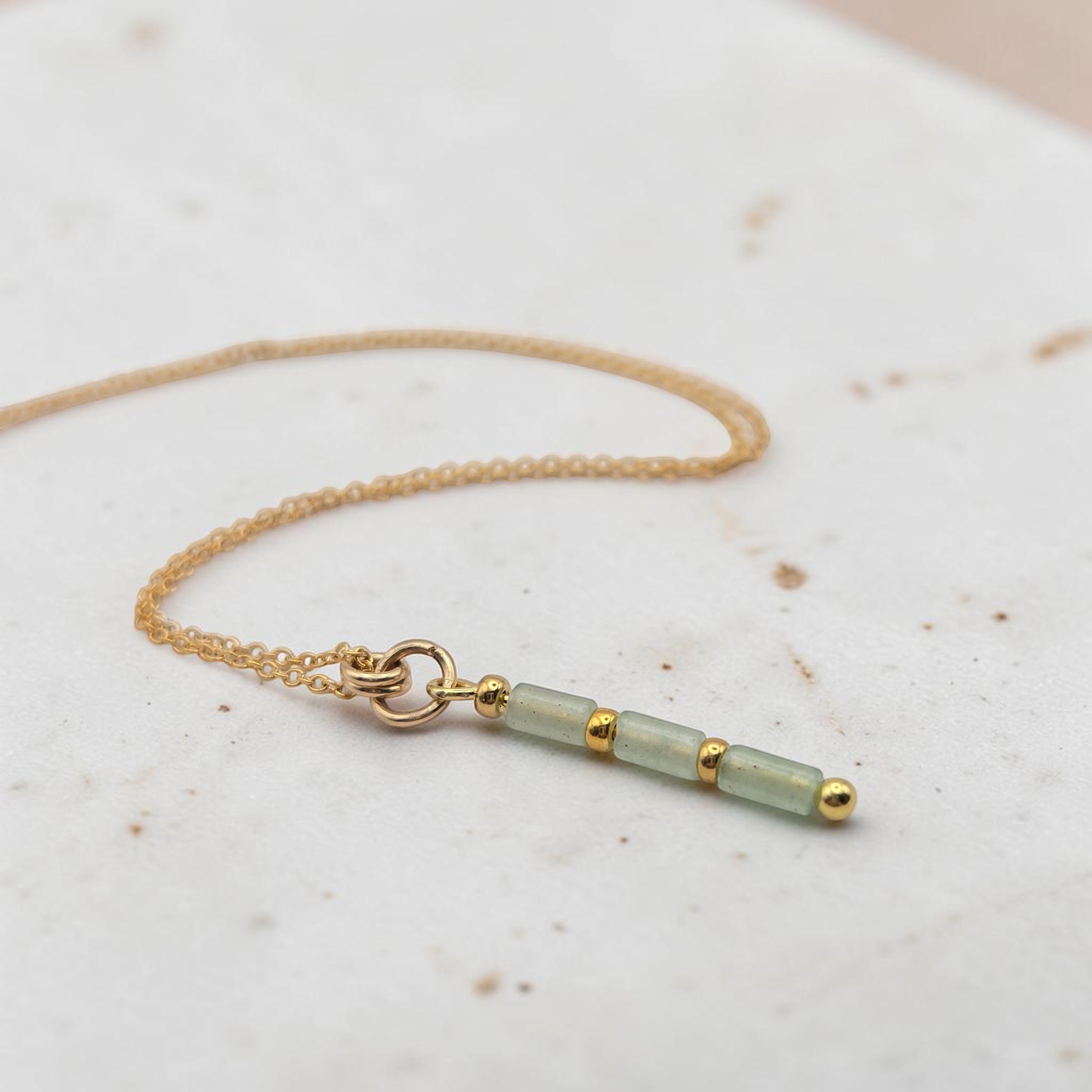 Bijou by SAM Mossy Creek necklace featuring green aventurine tube beads and 14k gold fill chain on a stone surface.