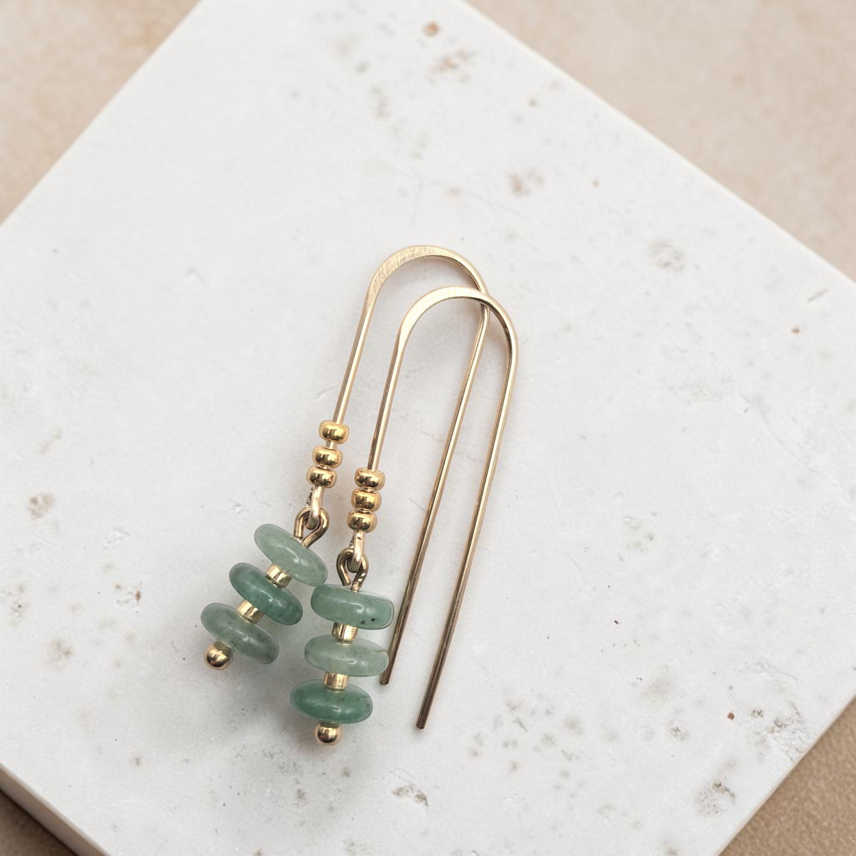 Bijou by SAM Comet Threader earrings featuring green aventurine beads and 14k gold fill on a textured white surface.