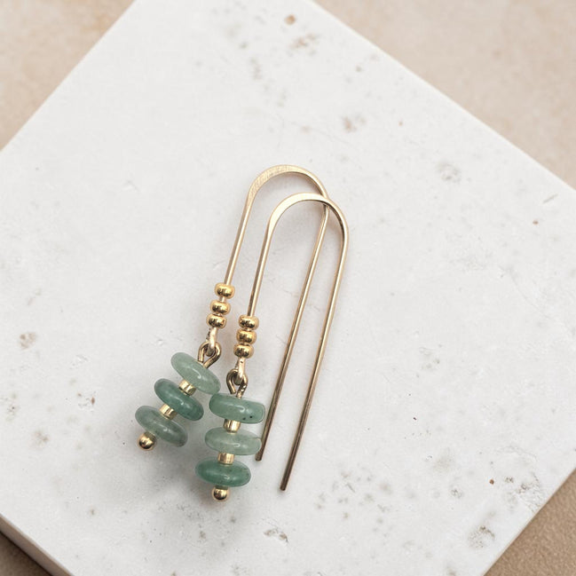 Bijou by SAM Comet Threader earrings featuring green aventurine beads and 14k gold fill on a textured white surface.