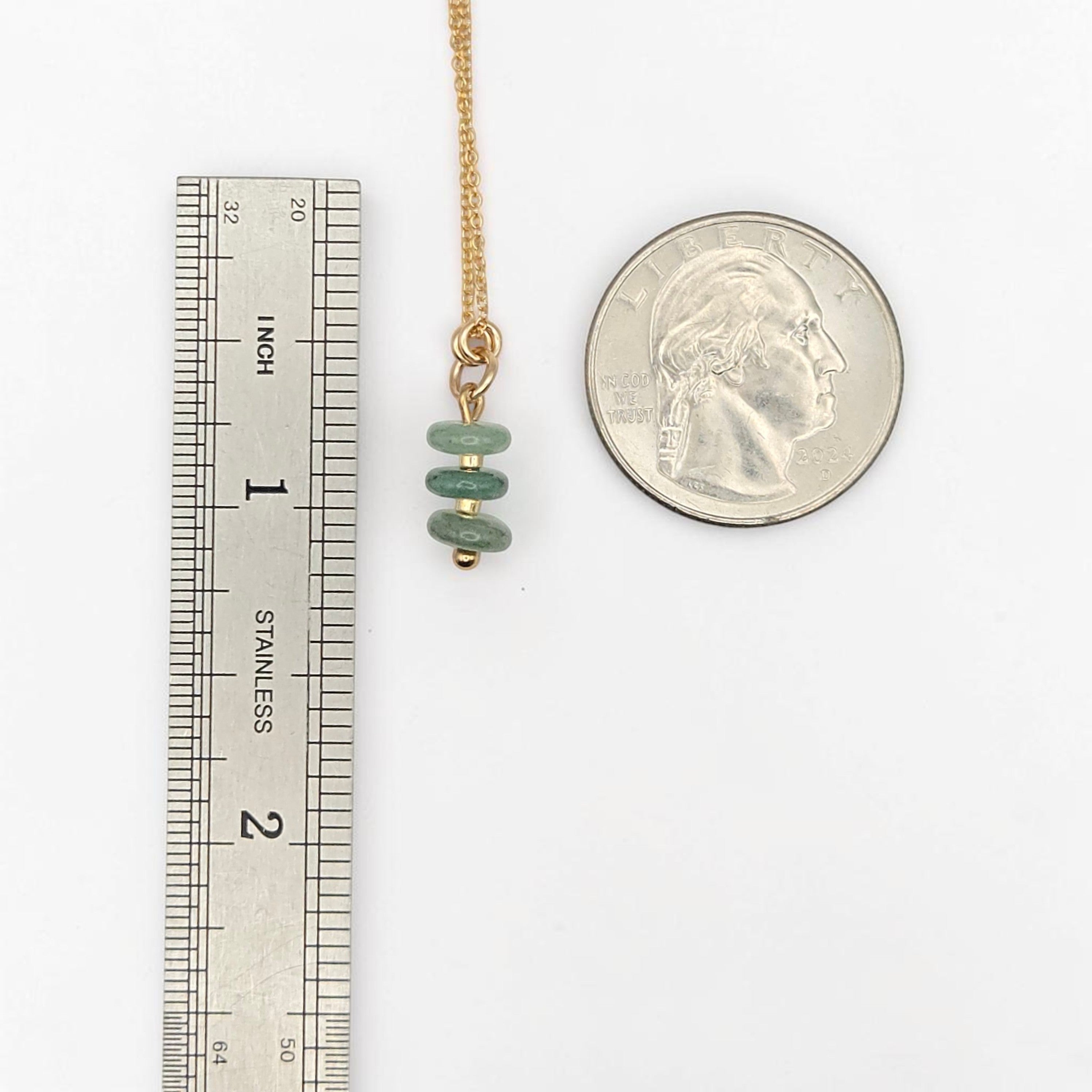 Bijou by SAM Comet necklace featuring three green aventurine stone beads on a delicate gold chain for scale.