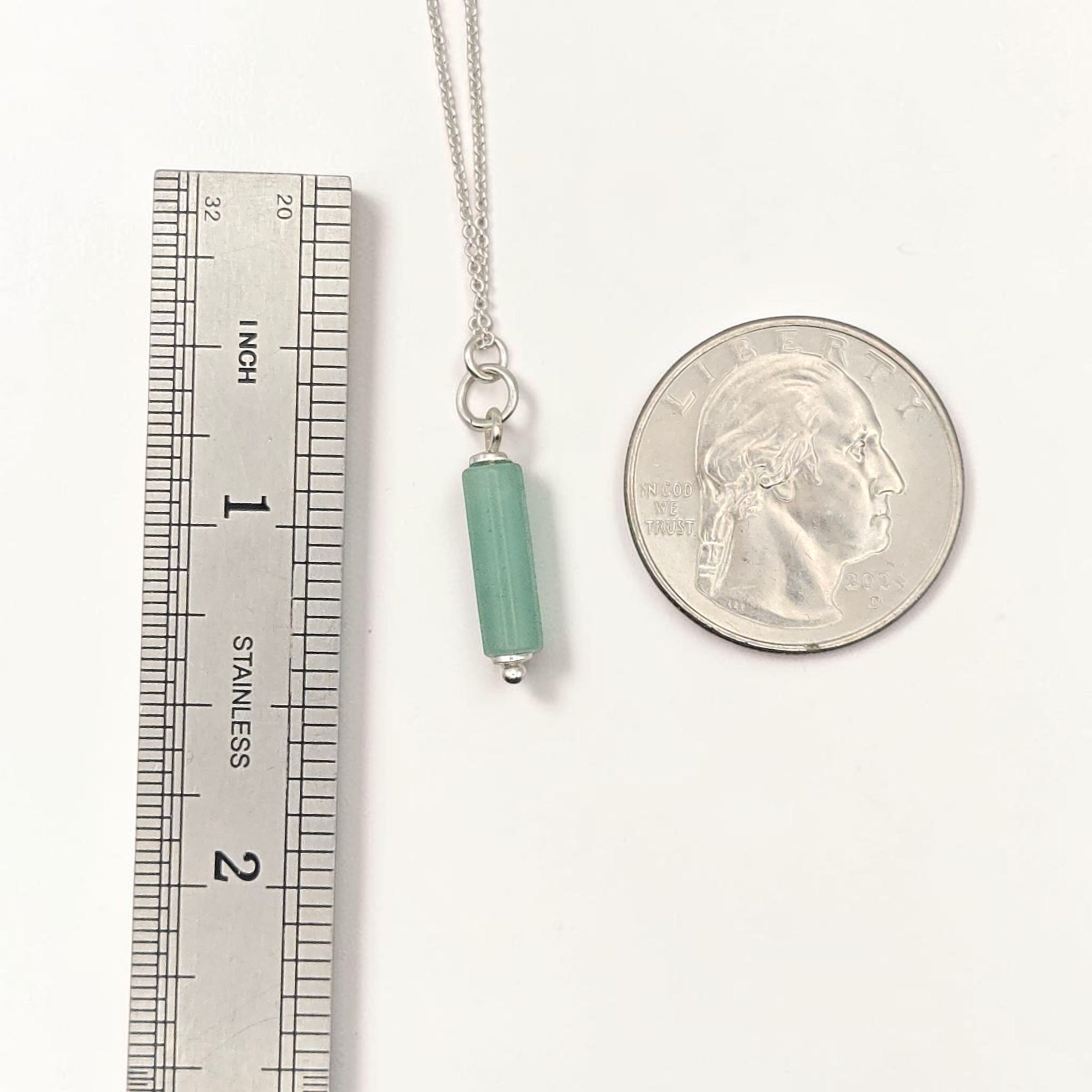 Bijou by SAM Ava necklace featuring a green aventurine cylinder bead on a delicate sterling silver chain next to a coin.