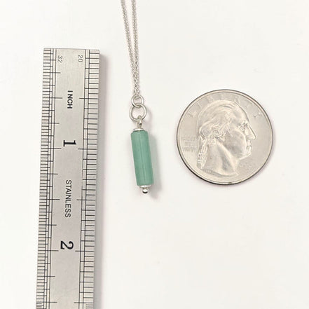 Bijou by SAM Ava necklace featuring a green aventurine cylinder bead on a delicate sterling silver chain next to a coin.