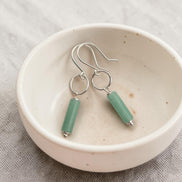 Bijou by SAM Ava earrings featuring cylindrical green aventurine gemstones on sterling silver hoops in a ceramic bowl.
