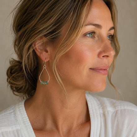 Bijou by SAM Comet teardrop hoop earrings featuring green aventurine stones on a woman wearing a white top